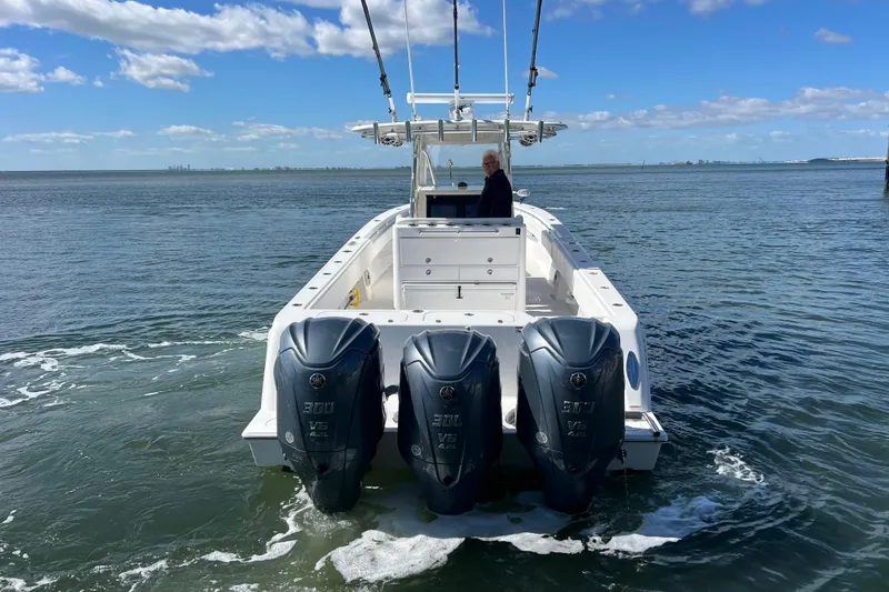 Slide: The Image of 2023 Contender 39 ST boat with triple Yamaha engines on open water. - 28