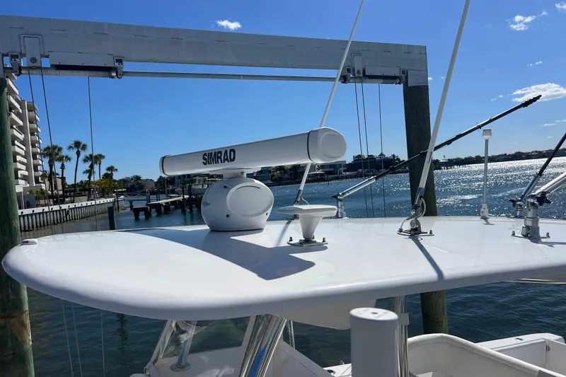 Slide: The Image of 2023 Contender 39 ST boat with Simrad radar, docked by waterfront under clear blue sky. - 30