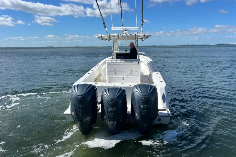 Slide: The Image of 2023 Contender 39 ST boat with triple outboard engines on open water. - 5