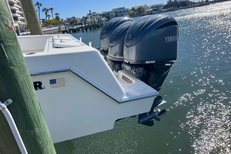 Slide: The Image of 2023 Contender 39 ST boat with dual Yamaha outboard engines docked by the water. - 7