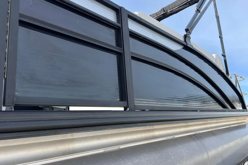 Slide: The Image of 2023 Harris Cruiser 210 SL pontoon boat, sleek black side panel design. - 13