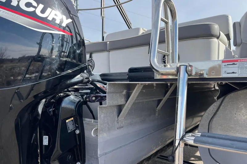 Slide: The Image of 2023 Harris Cruiser 210 SL boat with Mercury engine, rear seating, and stainless steel ladder. - 19