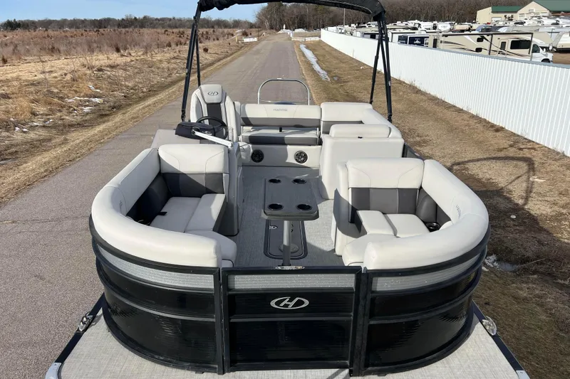 Slide: The Image of 2023 Harris Cruiser 210 SL pontoon boat with spacious seating on a rural road. - 2