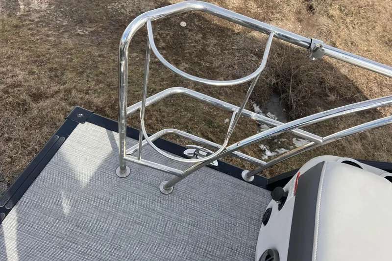 Slide: The Image of 2023 Harris Cruiser 210 SL boat deck with metal railing and seat. - 24