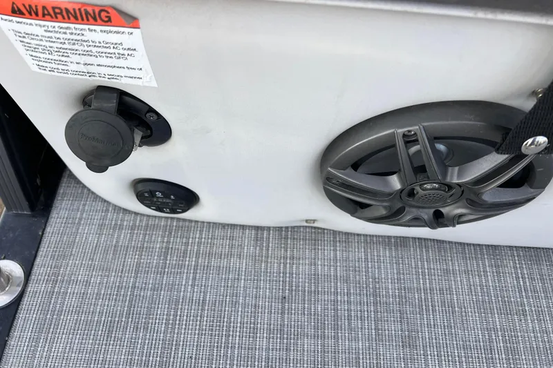 Slide: The Image of 2023 Harris Cruiser 210 SL boat interior with speaker and warning label. - 25