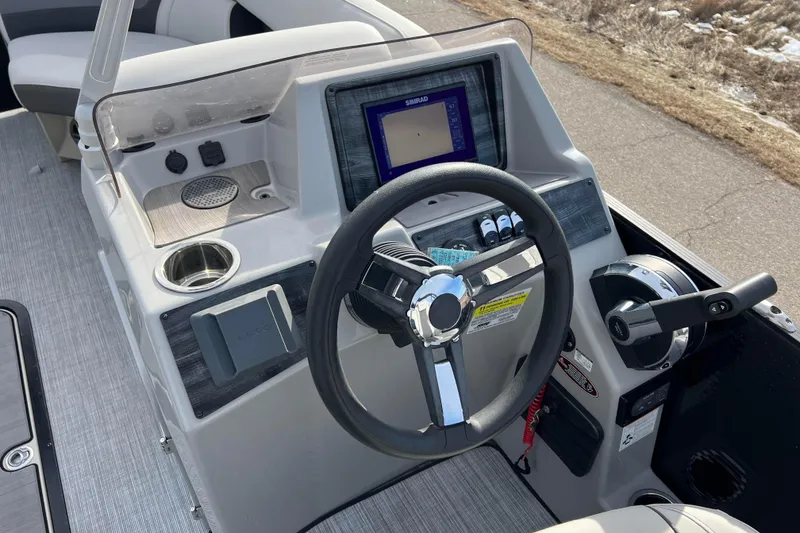 Slide: The Image of 2023 Harris Cruiser 210 SL boat dashboard with steering wheel and navigation display. - 38