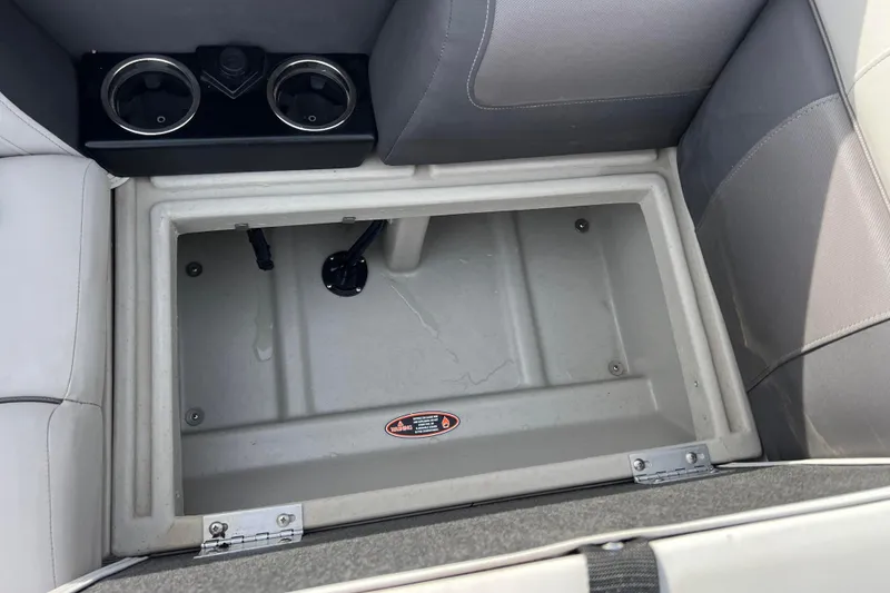 Slide: The Image of 2023 Harris Cruiser 210 SL storage compartment with cup holders and gray seating. - 45
