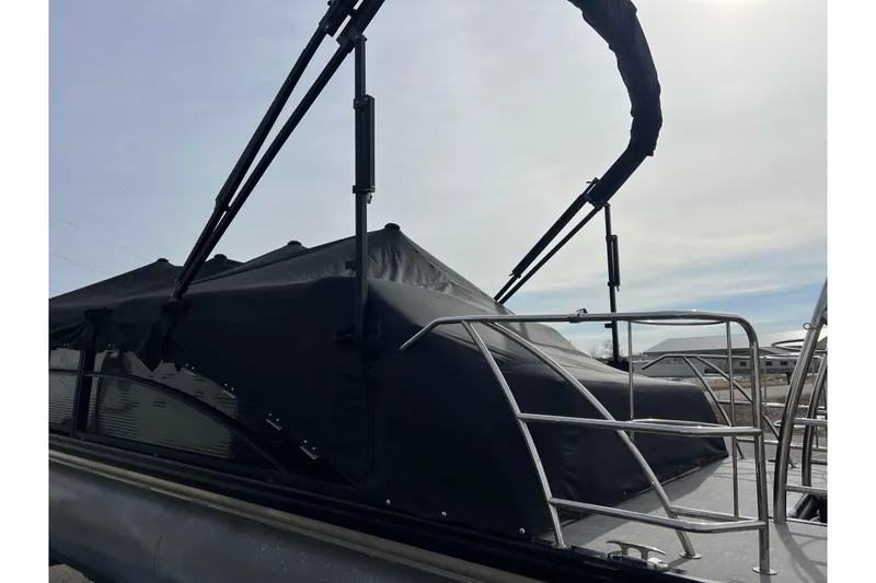 Slide: The Image of 2023 Harris Cruiser 210 SL boat with black canopy and metal railings. - 51