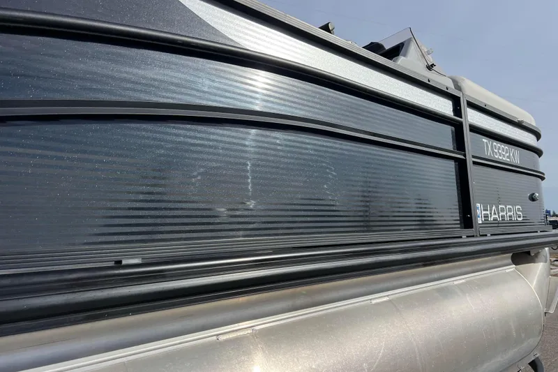 Slide: The Image of 2023 Harris Cruiser 210 SL pontoon boat side view with sleek design. - 7