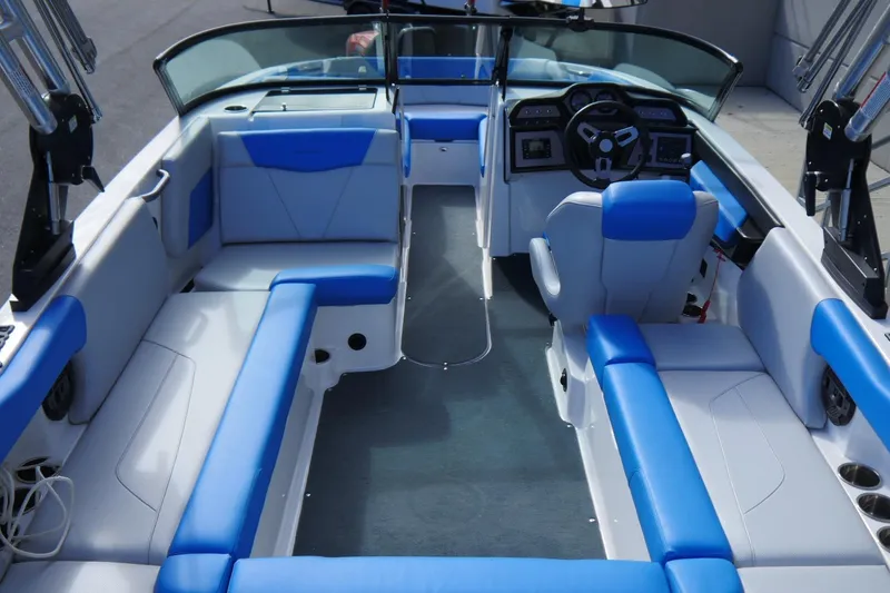 Slide: The Image of 2020 MasterCraft NXT22 boat interior with blue and white seating, modern dashboard, and spacious layout. - 10