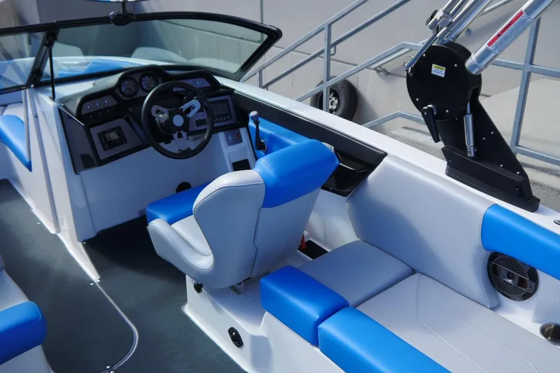 Slide: The Image of 2020 MasterCraft NXT22 boat interior with blue and white seating and modern dashboard. - 12