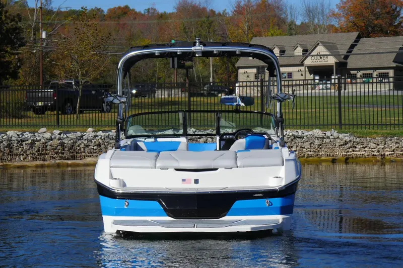 Slide: The Image of 2020 MasterCraft NXT22 boat on water, front view, with trees and building in background. - 3