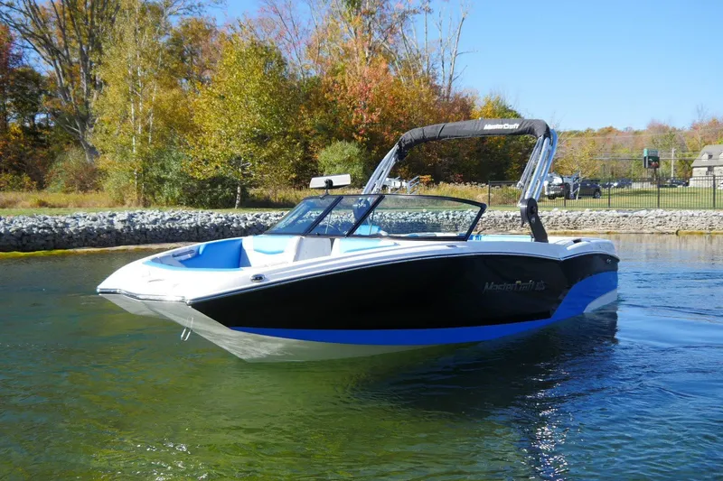 Slide: The Image of 2020 MasterCraft NXT22 boat on a serene lake with autumn foliage background. - 4
