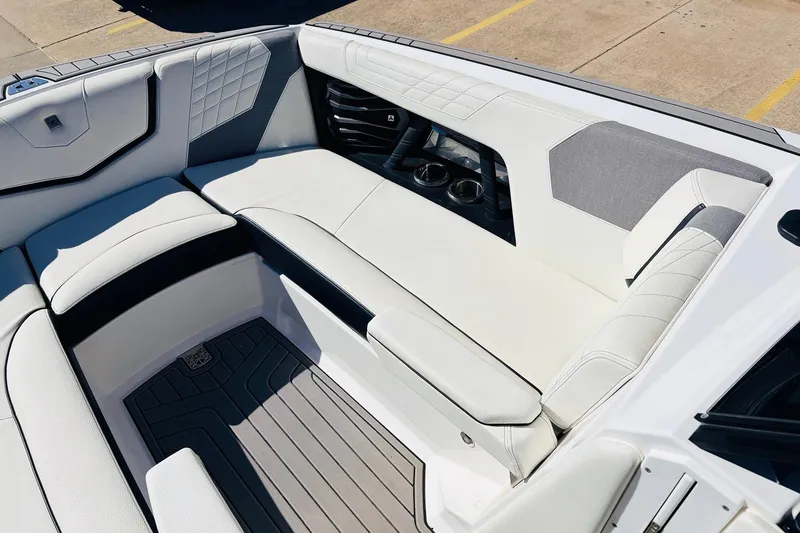 Slide: The Image of 2023 Nautique Super Air Nautique G25 interior with luxurious white seating and cup holders. - 16