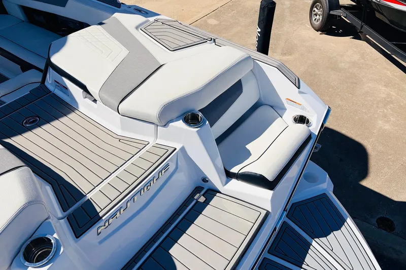 Slide: The Image of 2023 Nautique Super Air Nautique G25 boat interior with sleek seating and cup holders. - 61