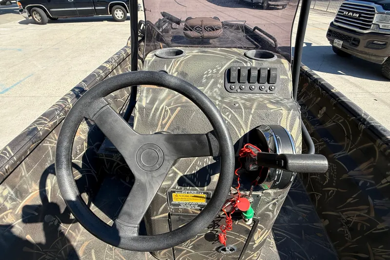 Slide: The Image of Steering console of 2018 Excel F86 boat with camouflage design in a parking lot. - 12