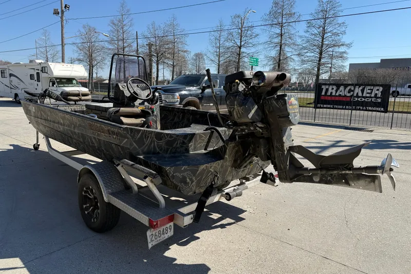 Slide: The Image of 2018 Excel F86 boat on trailer, camo design, parked outdoors near RV and vehicles. - 4