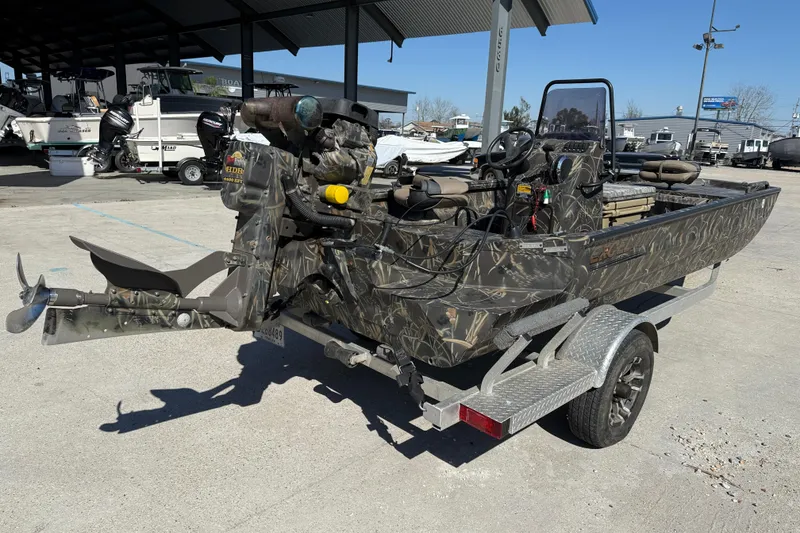 Slide: The Image of 2018 Excel F86 boat with camouflage design on a trailer in a marina setting. - 6