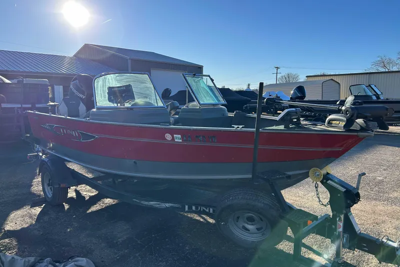 Slide: The Image of 2012 Lund 1775 Impact XS boat on trailer, parked outdoors under bright sunlight. - 4