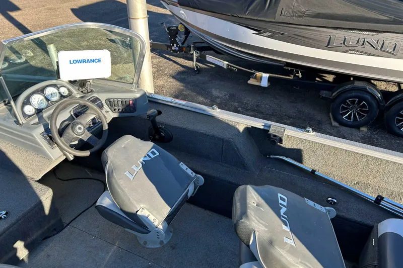 Slide: The Image of 2012 Lund 1775 Impact XS boat interior with Lowrance system and trailer in background. - 9
