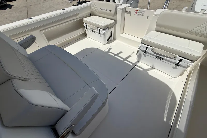 Slide: The Image of 2026 World Cat 325 CC boat interior with cushioned seating and Yeti coolers. - 12