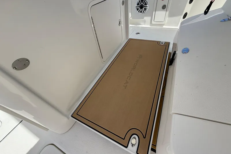 Slide: The Image of 2026 World Cat 325 CC boat deck with branded flooring and storage compartments. - 15