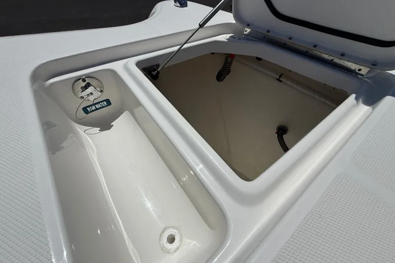Slide: The Image of Open storage compartment on 2026 World Cat 325 CC boat, featuring raw water access. - 20