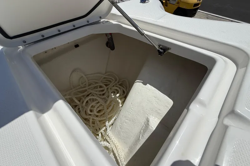 Slide: The Image of Open storage compartment on 2026 World Cat 325 CC boat with coiled rope inside. - 21