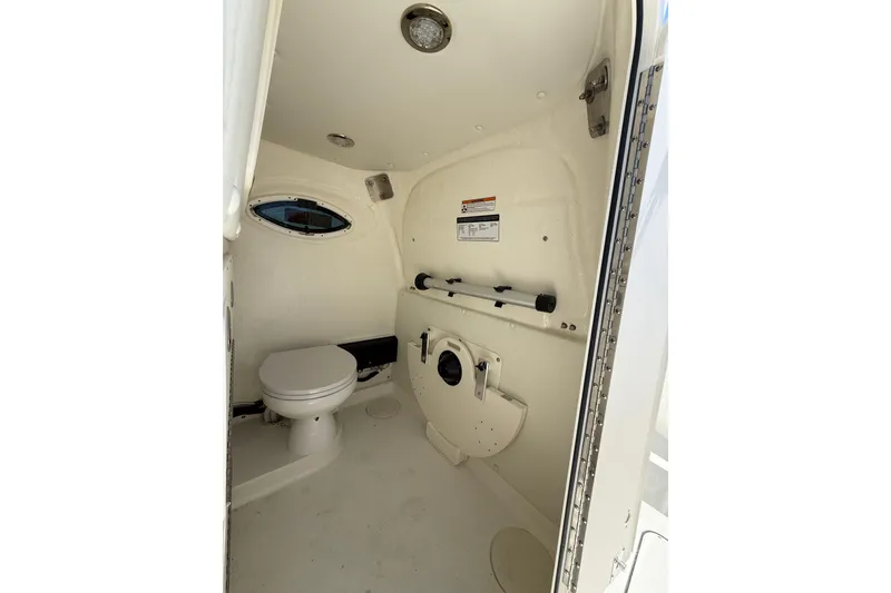 Slide: The Image of Interior of 2026 World Cat 325 CC boat bathroom with toilet and porthole window. - 24