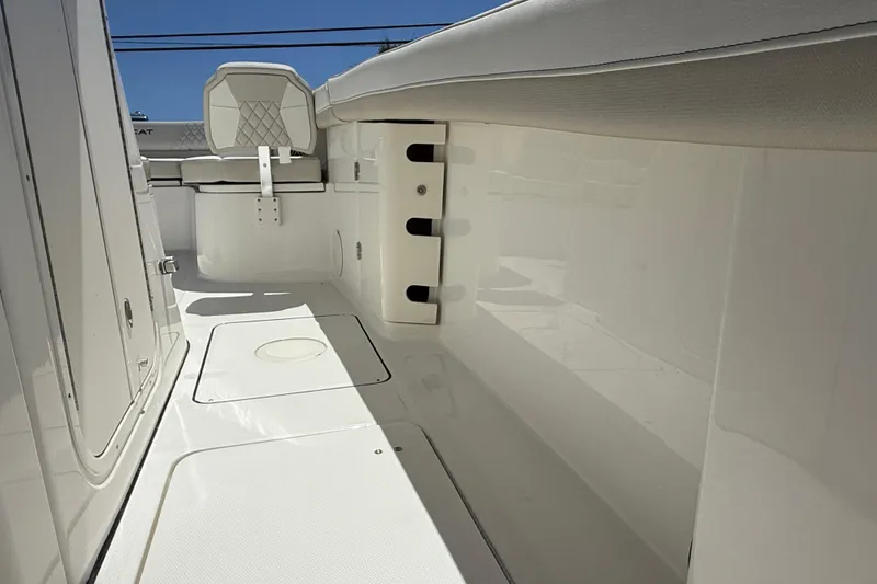 Slide: The Image of Interior view of 2026 World Cat 325 CC boat, featuring sleek white seating and storage compartments. - 25