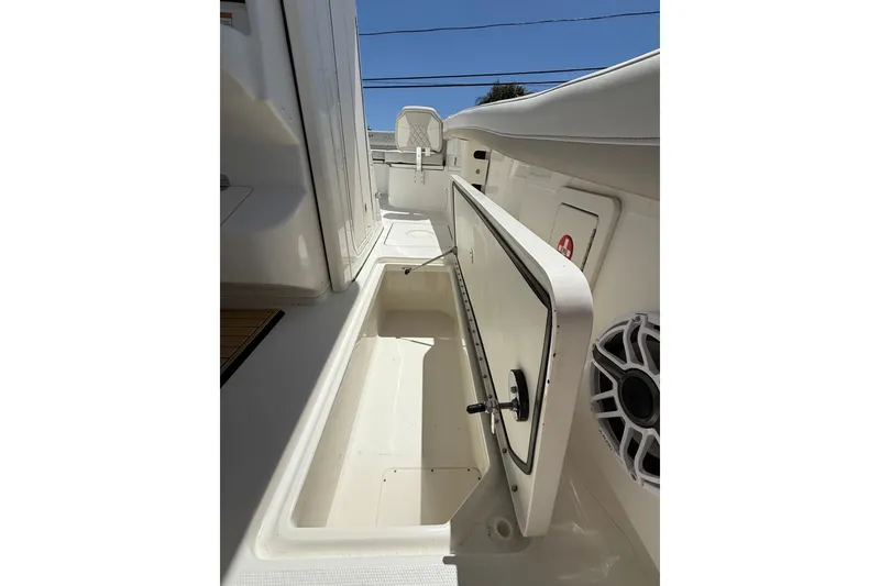 Slide: The Image of 2026 World Cat 325 CC boat interior with open storage compartment and speaker. - 26