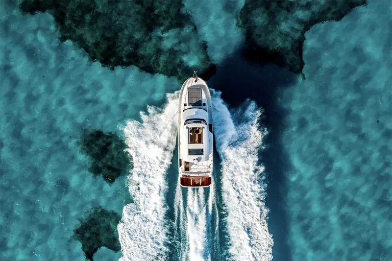 Slide: The Image of Manufacturer Provided Image: 2026 Beneteau Swift Trawler 48 cruising on clear turquoise waters, aerial view. - 3