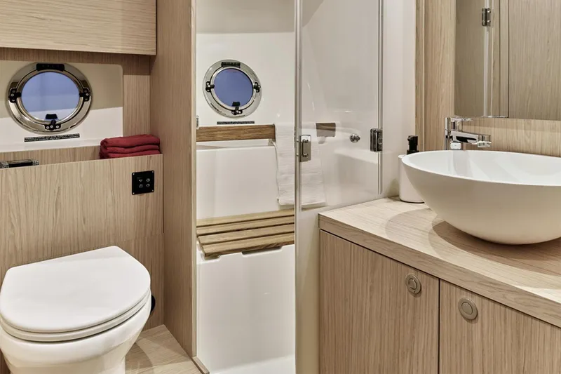 Slide: The Image of Manufacturer Provided Image: Luxurious bathroom in 2026 Beneteau Swift Trawler 48 with modern fixtures and porthole windows. - 9