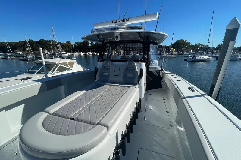 Slide: The Image of 2024 Freeman 42LR boat with sleek design, docked in a marina under clear blue skies. - 12