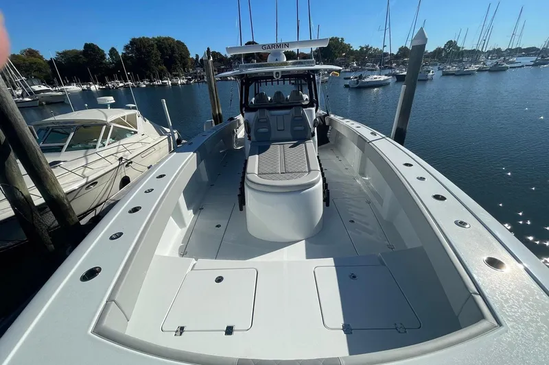 Slide: The Image of 2024 Freeman 42LR boat docked in a marina, surrounded by other vessels. - 13