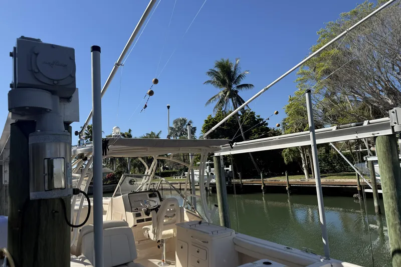 Slide: The Image of 2022 Grady-White Freedom 275 boat docked by a scenic canal with palm trees. - 31