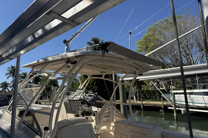 Slide: The Image of 2022 Grady-White Freedom 275 boat docked under a canopy, surrounded by trees. - 32