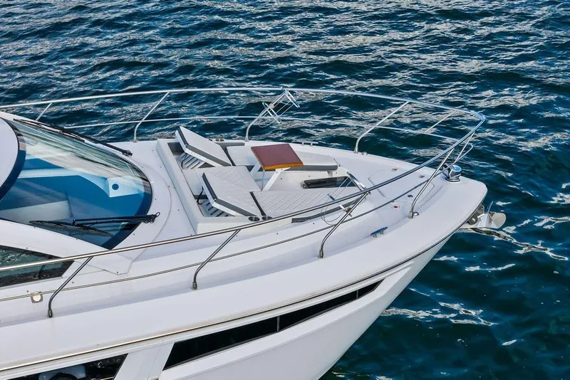 Slide: The Image of 2023 Cruisers 42 Cantius yacht with sun loungers on deck, cruising on open water. - 10