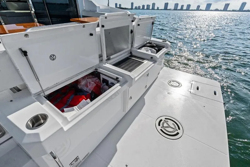 Slide: The Image of 2023 Cruisers 42 Cantius yacht deck with open storage compartments by the water. - 18