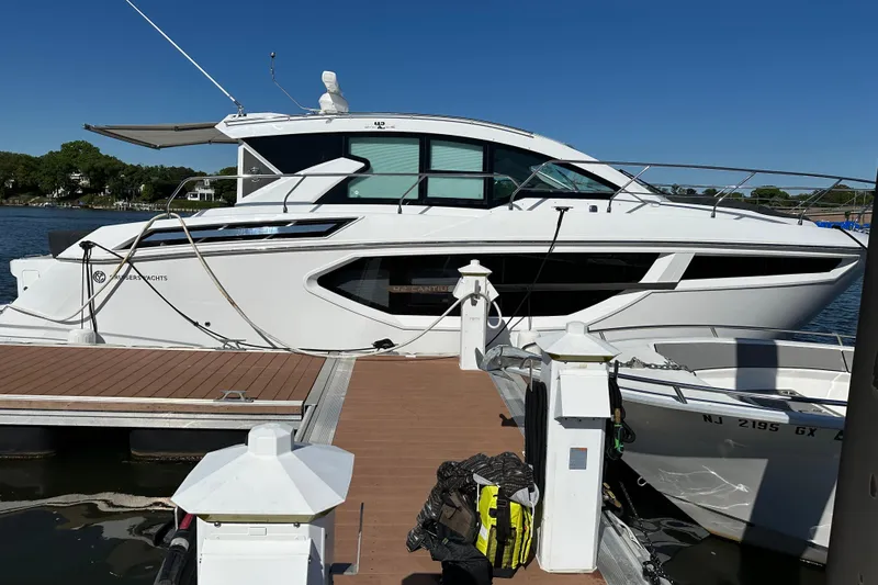 Slide: The Image of 2023 Cruisers 42 Cantius yacht docked at marina under clear blue sky. - 2