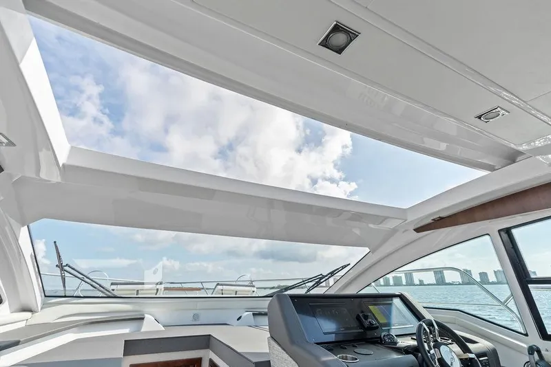Slide: The Image of Interior view of 2023 Cruisers 42 Cantius yacht with open sunroof and modern helm. - 30