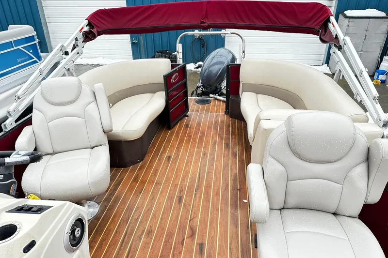 Slide: The Image of 2016 Crest Pontoon SLC OPT with beige seating and wooden deck, featuring a maroon canopy. - 3