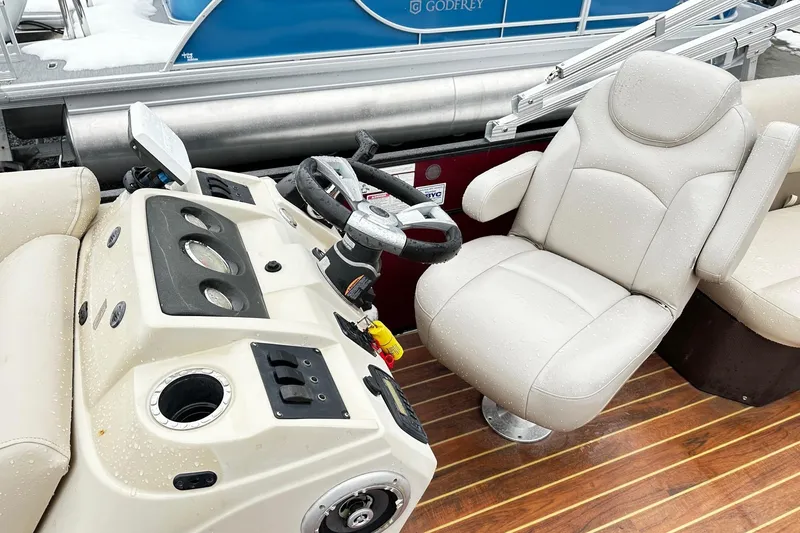Slide: The Image of 2016 Crest Pontoon SLC OPT interior with steering wheel and captain's chair on wooden deck. - 5