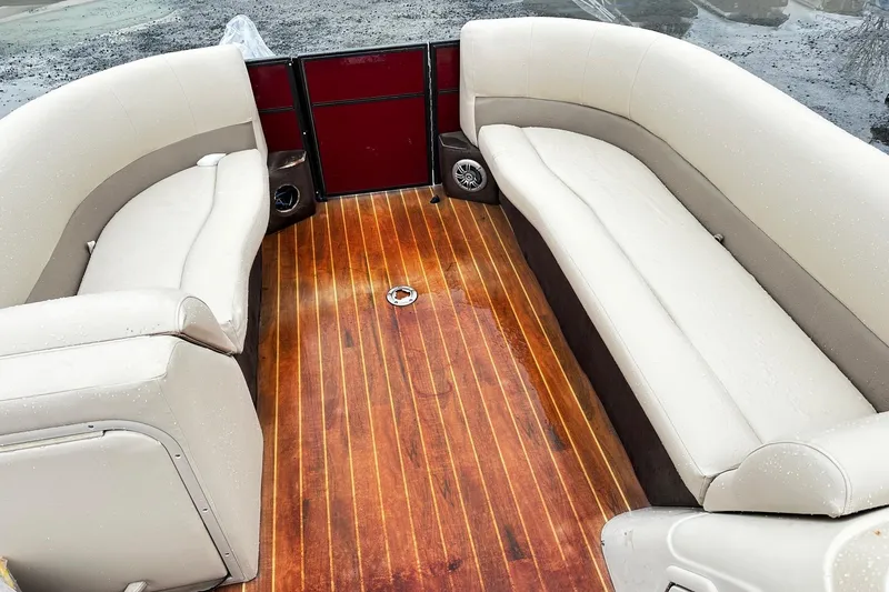 Slide: The Image of 2016 Crest Pontoon SLC OPT interior with beige seating and wooden flooring. - 7