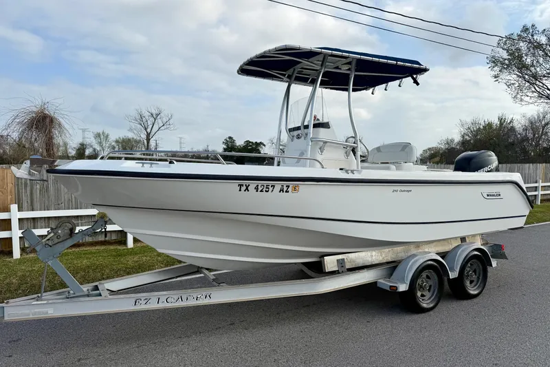The Image of 2008 Boston Whaler 210 Outrage boat on trailer, parked on roadside. - 1