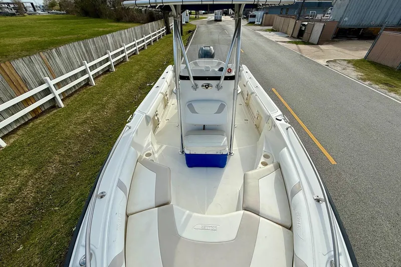 Slide: The Image of 2008 Boston Whaler 210 Outrage boat with spacious seating and center console on a road. - 14
