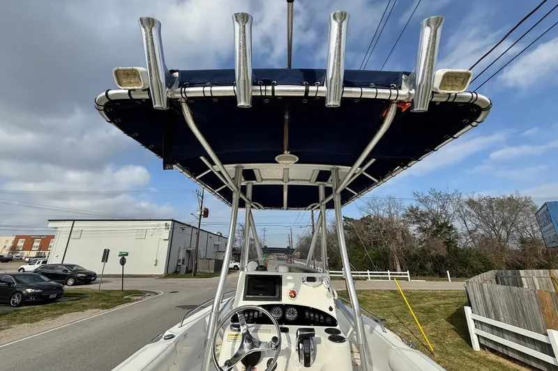 Slide: The Image of 2008 Boston Whaler 210 Outrage boat with T-top and console, parked on a street. - 16