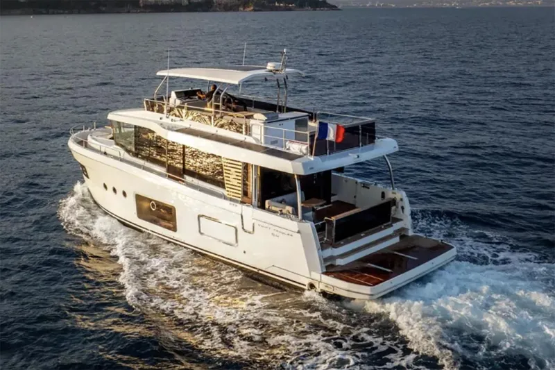 Slide: The Image of Manufacturer Provided Image: 2026 Beneteau Swift Trawler 54 cruising on open water, rear view. - 3