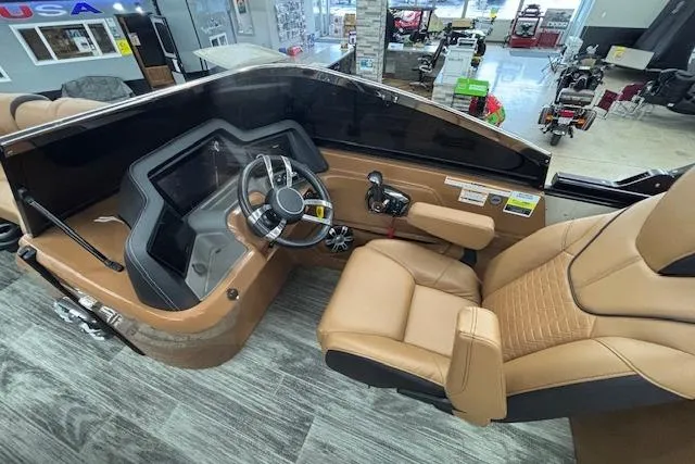 Slide: The Image of 2023 Avalon Catalina 2585 QL boat interior with tan leather seats and modern dashboard. - 12