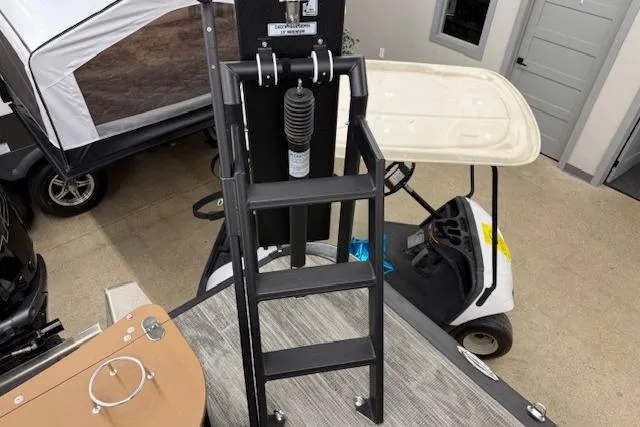 Slide: The Image of 2023 Avalon Catalina 2585 QL boat ladder in showroom with golf cart in background. - 19